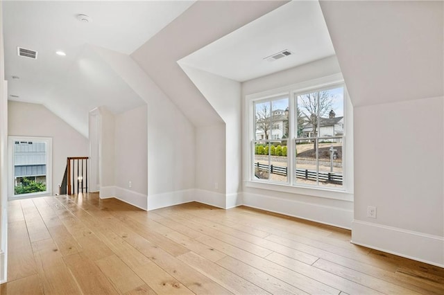 bonus room featuring vaulted ceiling, visible vents, baseboards, and light wood-type flooring