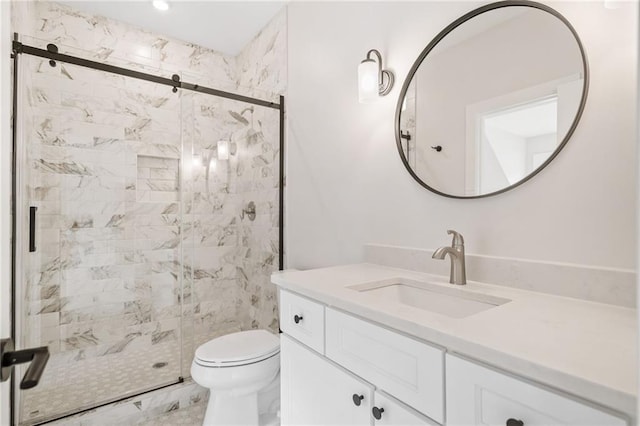 bathroom with a shower stall, toilet, and vanity