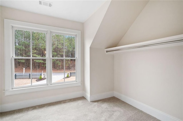 bonus room featuring lofted ceiling, visible vents, baseboards, and light carpet