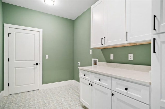 clothes washing area with electric dryer hookup, cabinet space, hookup for a washing machine, and baseboards