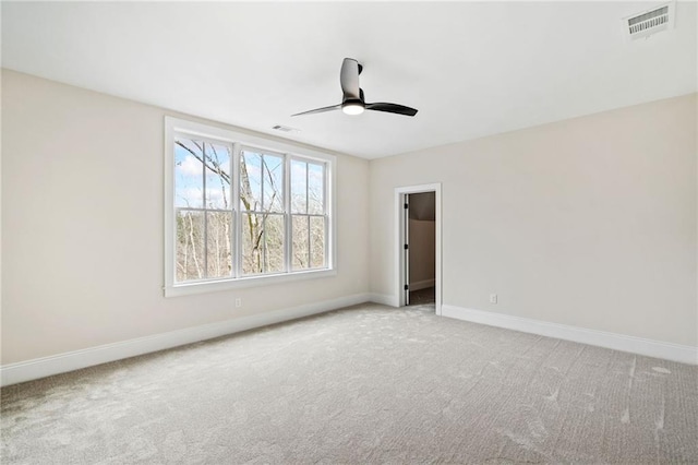 carpeted empty room featuring baseboards, a ceiling fan, and visible vents