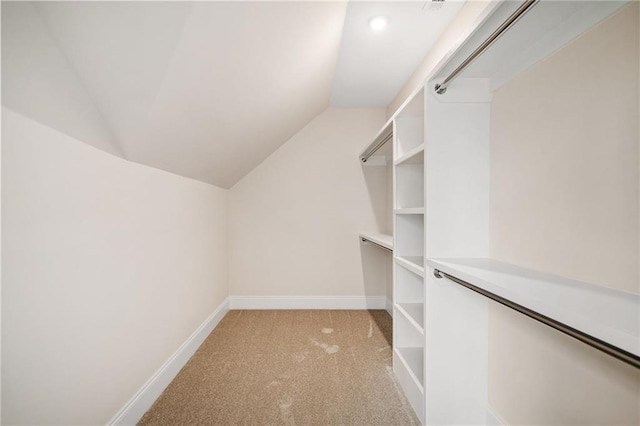 spacious closet featuring vaulted ceiling and light colored carpet