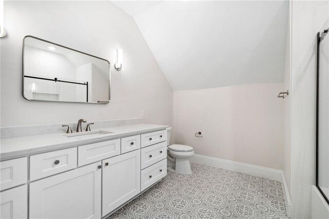 bathroom with vaulted ceiling, vanity, toilet, and walk in shower