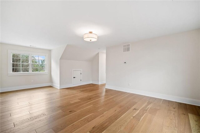bonus room featuring baseboards, visible vents, and light wood-style floors