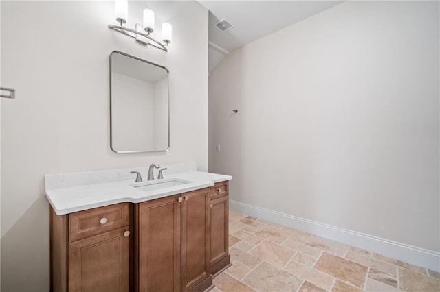 bathroom with stone finish flooring, baseboards, vanity, and visible vents
