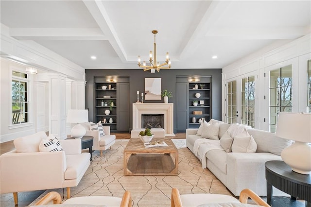 living room featuring wood finished floors, a chandelier, built in shelves, beamed ceiling, and recessed lighting