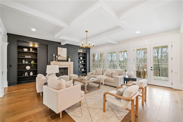 living room with a fireplace, light wood-style floors, plenty of natural light, and built in features