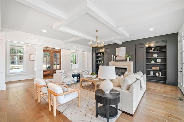 living area featuring built in shelves, recessed lighting, beam ceiling, and light wood-type flooring