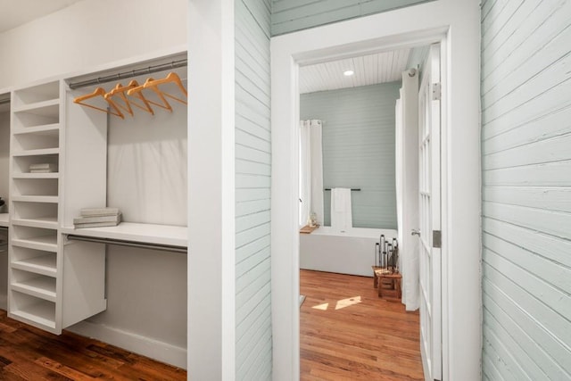 walk in closet with wood finished floors