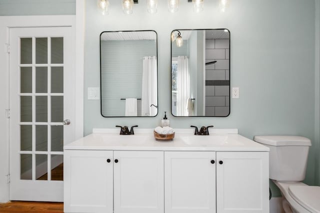 full bathroom with toilet and double vanity