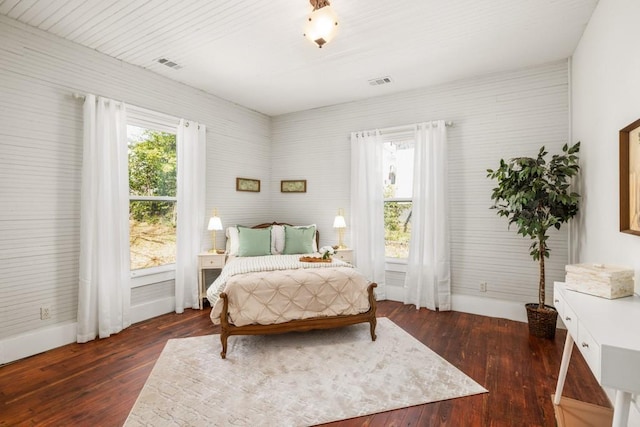 bedroom with baseboards and dark wood-type flooring