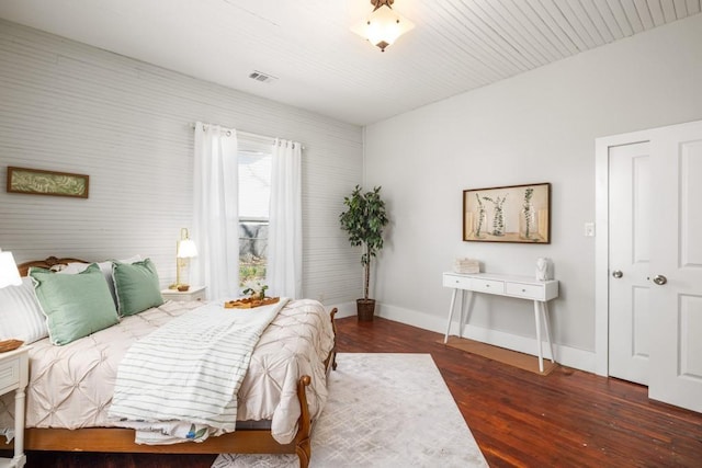 bedroom with wood finished floors and baseboards