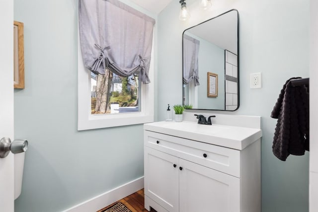 bathroom featuring vanity, baseboards, and wood finished floors