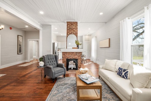 living area with a fireplace, wood finished floors, baseboards, and recessed lighting