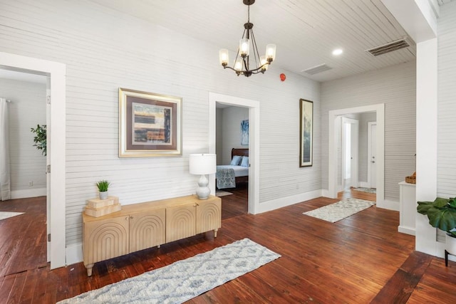 foyer with a chandelier, baseboards, and hardwood / wood-style floors