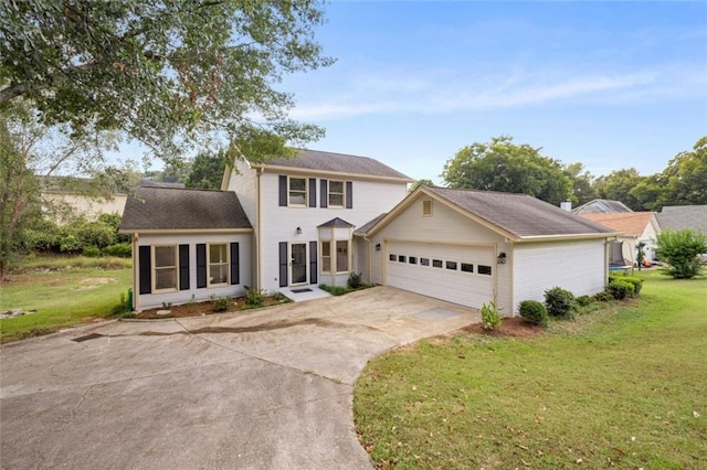 colonial home featuring a front yard and a garage