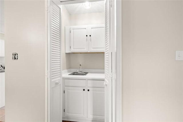 clothes washing area with a textured ceiling and sink