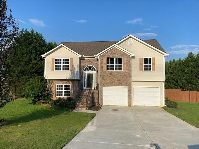 bi-level home featuring a garage and a front lawn