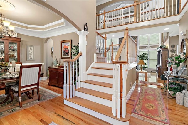 580 River Valley Dr, Dacula, GA 30019 - staircase featuring arched walkways, ornamental molding, wood finished floors, decorative columns, and a tray ceiling