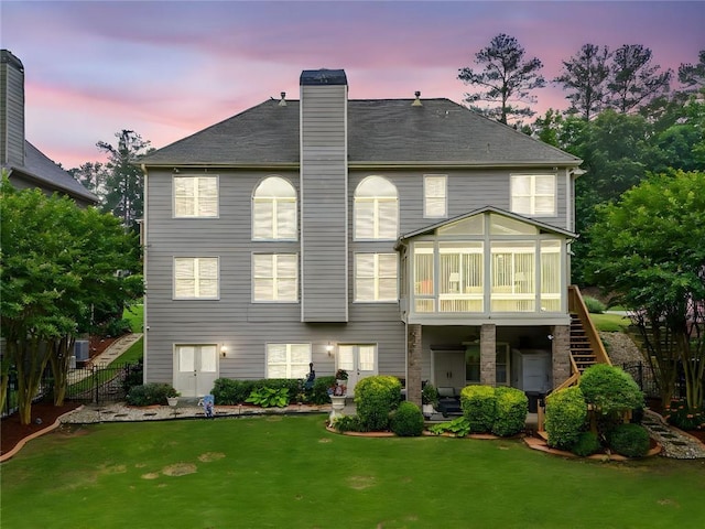 580 River Valley Dr, Dacula, GA 30019 - back of property at dusk featuring a sunroom, stairs, a chimney, a patio, and french doors