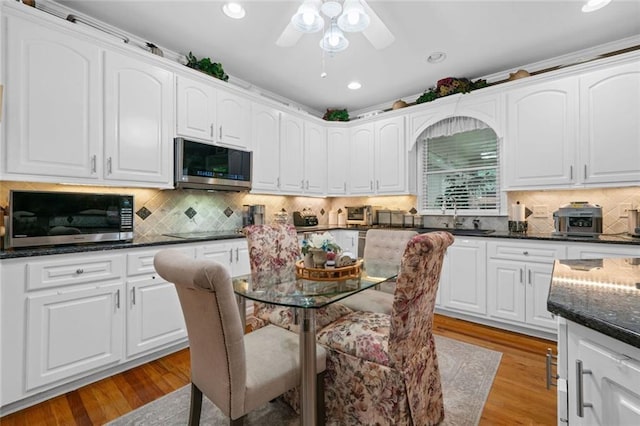 580 River Valley Dr, Dacula, GA 30019 - kitchen featuring stainless steel microwave, a sink, white cabinetry, recessed lighting, and backsplash