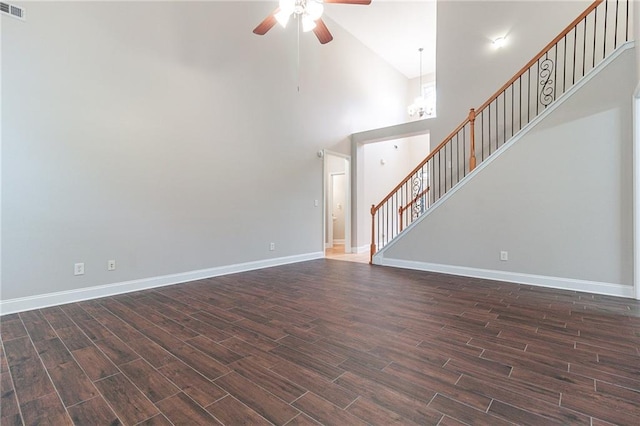 unfurnished living room with ceiling fan with notable chandelier and high vaulted ceiling