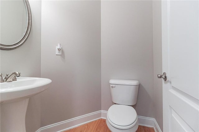 bathroom with sink, hardwood / wood-style floors, and toilet