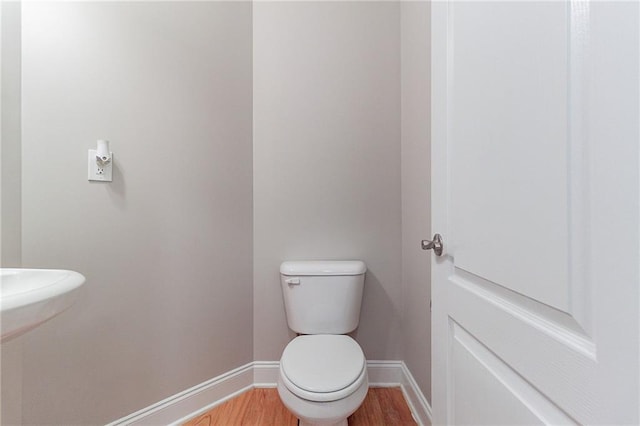 bathroom featuring hardwood / wood-style flooring and toilet