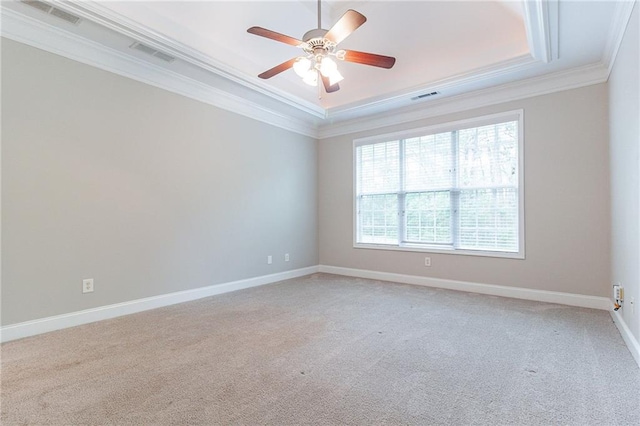 carpeted empty room featuring a tray ceiling, ceiling fan, and ornamental molding