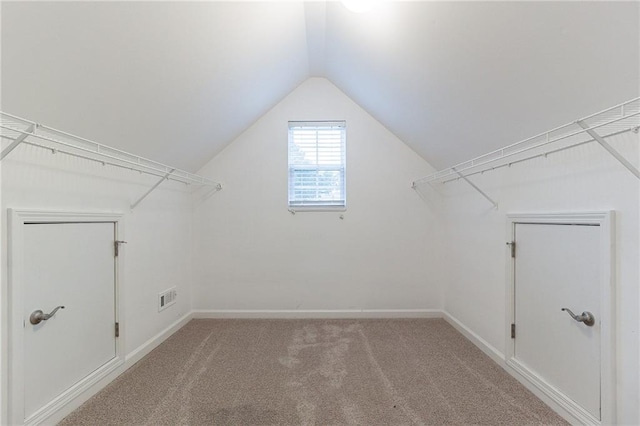 walk in closet with carpet and lofted ceiling