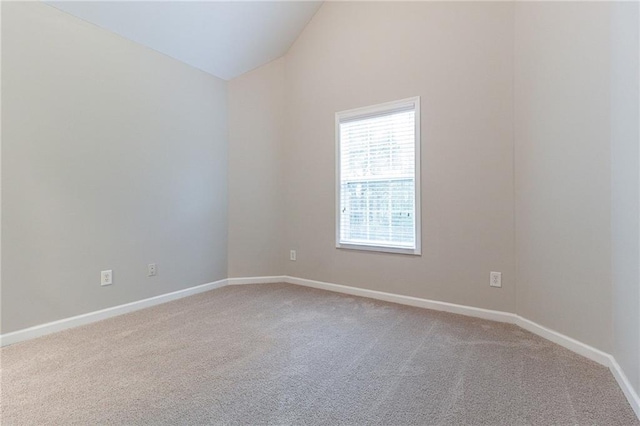 empty room with carpet flooring and vaulted ceiling