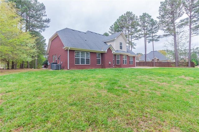 back of property with a lawn and central AC unit