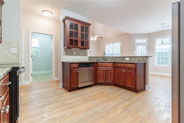 kitchen featuring dishwasher, sink, light hardwood / wood-style flooring, backsplash, and kitchen peninsula