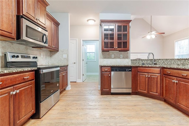 kitchen featuring light stone countertops, sink, ceiling fan, lofted ceiling, and appliances with stainless steel finishes