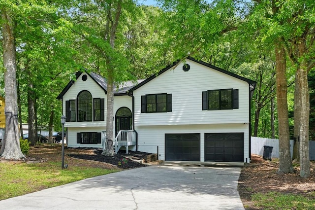 raised ranch featuring a garage and driveway