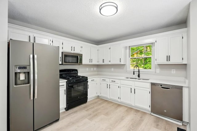 kitchen featuring a sink, light countertops, white cabinets, and stainless steel appliances