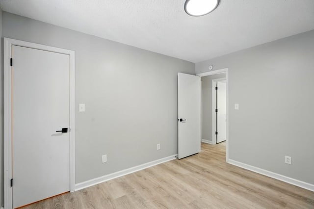 unfurnished bedroom featuring baseboards and light wood finished floors