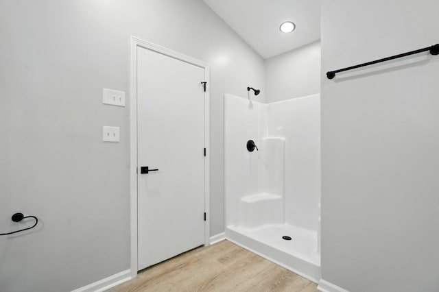 full bathroom featuring baseboards, walk in shower, and wood finished floors