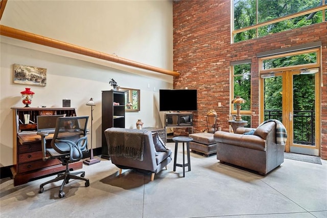 319 Atlanta St SE Unit 315, Marietta, GA 30060 - living area with a high ceiling, concrete flooring, brick wall, and a desk