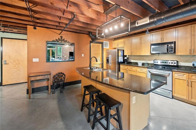319 Atlanta St SE Unit 315, Marietta, GA 30060 - kitchen featuring appliances with stainless steel finishes, a sink, concrete floors, a breakfast bar area, and a center island with sink