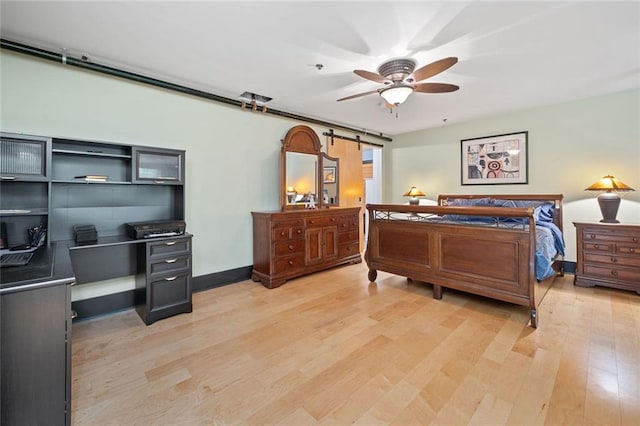 319 Atlanta St SE Unit 315, Marietta, GA 30060 - bedroom featuring a barn door, light wood-style floors, a desk, baseboards, and a ceiling fan