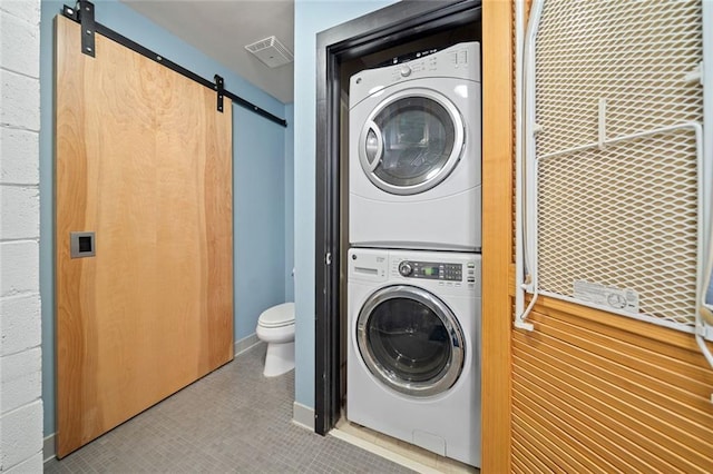 319 Atlanta St SE Unit 315, Marietta, GA 30060 - laundry room with estacked washer and dryer, a barn door, and tile patterned flooring
