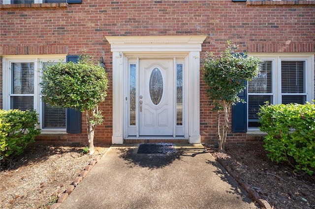 doorway to property featuring brick siding