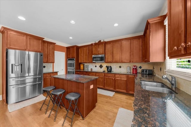 3086 Frazier Walk, Decatur, GA 30033 - kitchen with appliances with stainless steel finishes, a sink, a center island, light wood-style flooring, and brown cabinetry