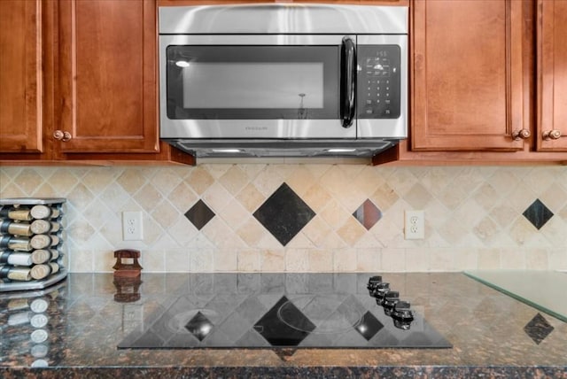 3086 Frazier Walk, Decatur, GA 30033 - kitchen with stainless steel microwave, black electric cooktop, brown cabinets, and tasteful backsplash