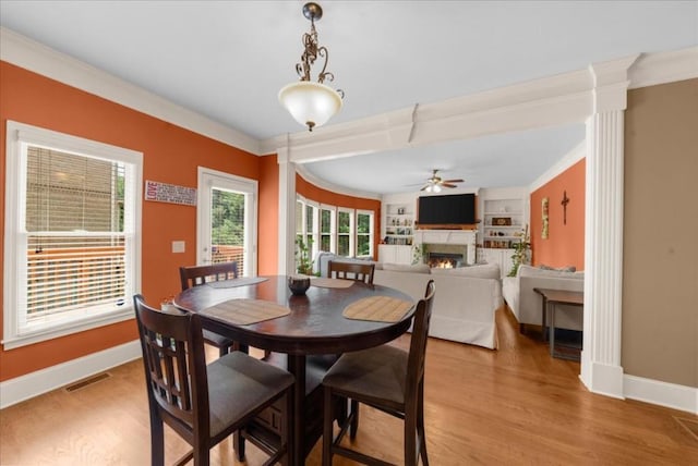 3086 Frazier Walk, Decatur, GA 30033 - dining area with a lit fireplace, a ceiling fan, baseboards, light wood-type flooring, and ornamental molding