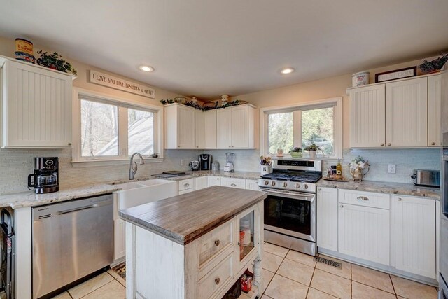 kitchen with a kitchen island, white cabinetry, appliances with stainless steel finishes, and sink