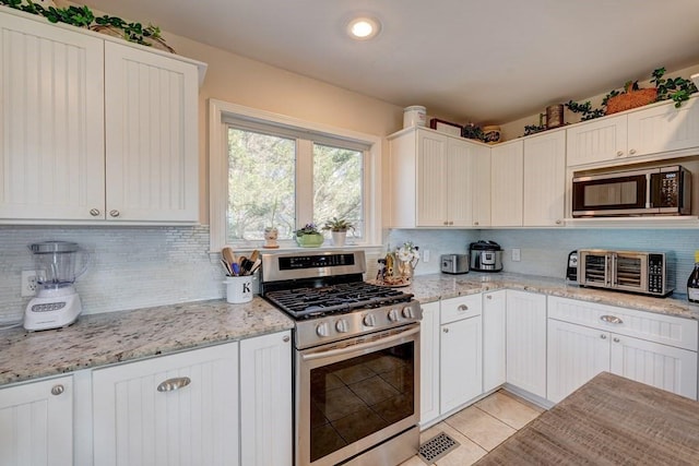 kitchen featuring white cabinetry, light stone counters, and appliances with stainless steel finishes