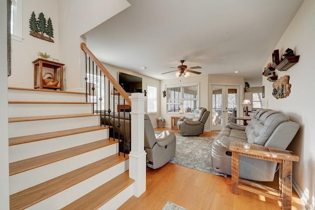 living room featuring light hardwood / wood-style flooring, ceiling fan, and french doors