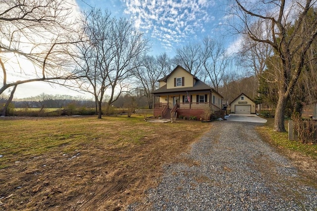 view of front of home with an outbuilding, a garage, a front yard, and a porch